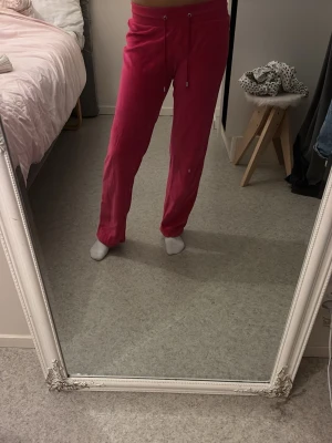 Rosa 2000-tals mjukisbyxor från champion - Säljer ett par snygga rosa mjukisbyxor med raka ben perfekt om man gillar 2000-tals stil. Byxorna är i mjukt velourmaterial och har en relaxed fit som är perfekt för chill dagar. De är från champion i storlek S, längden på byxorna är lite kortare så passar bäst för de som är kortare än 160 cm.