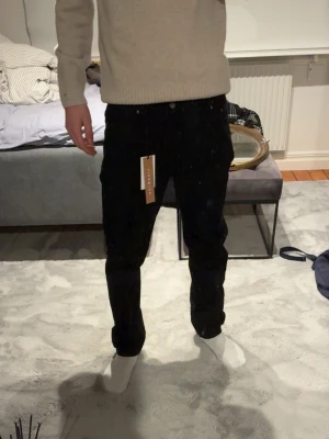 Svarta loose fit jeans från Grunt - Säljer ett par svarta loose fit jeans från Grunt, modell Street Loose Night. Jeansen har en avslappnad passform och raka ben, perfekta för en chill och trendig look. Klassisk femficksmodell med knappgylf. Materialet är mjukt och bekvämt.                      Skulle säga att dem passar dig med L30-L32