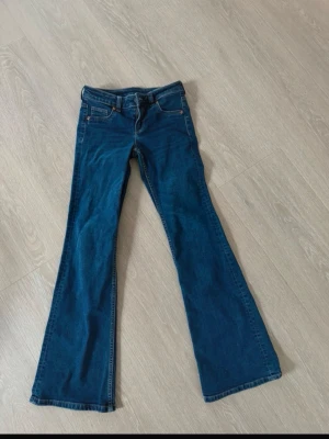 Blå bootcut jeans från H&M - Säljer ett par blå bootcut jeans från H&M med lågmidja. Använd fåtal gånger.