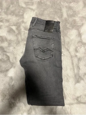 Grå jeans med raka ben - Säljer ett par grå jeans med raka ben och klassisk femficksdesign. Jeansen har dubbla bakfickor med dekorativ söm och bälteshällor. Materialet är mjukt denim och färgen är en snygg tvättad grå. Perfekta till en avslappnad stil. Stl W30 L34