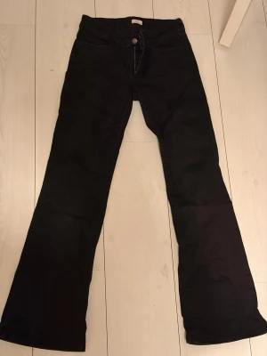 Svarta bootcut jeans från Nelly  - Säljer ett par svarta bootcut jeans från Nelly! Dom är i fint skick men råkat tvätta dom i fel grad så dom passar även storlek 36 men det är storlek 38 i byxorna. Fint skick!