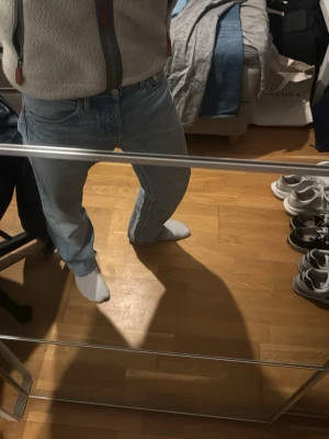 Ljusblå baggy jeans - Säljer ett par ljusblå jeans med rak passform och klassisk femficksdesign. Jeansen har normal midja och är tillverkade i ett mjukt denimtyg som ger en avslappnad look. Perfekta för dig som gillar en enkel och stilren stil.