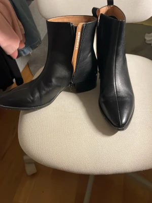 Svarta skinnstövletter med klack - Snygga svarta stövletter i äkta skinn med spetsig tå och låg, bred klack. Dragkedja på insidan och stilren design med diskreta sömmar!!