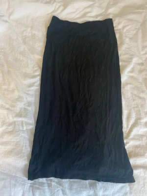 Svart långkjol med slits - En svart långkjol i mjukt tyg med en snygg slits på sidan. Kjolen har en enkel och stilren design som passar till många olika looks. Använd flitigt men fortfarande fin.