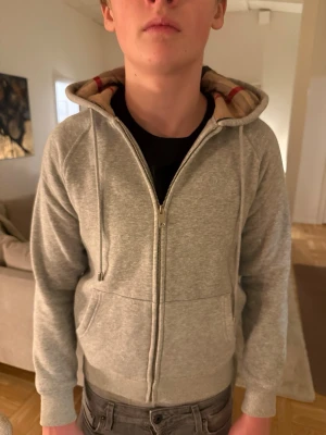 Burberry zip-up grå - Burberry grå zip-up hoodie – helt ny Helt ny och oanvänd Burberry zip-up hoodie i grå färg. Stilren och tidlös design med hög kvalitet och skön passform. Använd fåtal gånger då sonen växte fort , i perfekt skick. Perfekt både till vardags och finare outfits.