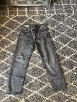 Grå slim fit jeans från Dr. Denim - Snygga grå slim fit jeans från Dr. Denim med klassisk femficksdesign och knappgylf. Jeansen har en tvättad look och raka ben som smalnar av. Perfekta för dig som gillar en enkel men trendig stil.