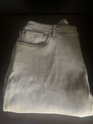 Ljusgråa Jacob Cohën jeans - Snygga grå jeans från Jacob Cohën tillverkad i ett mjukt denim material som gör jeansen otroligt sköna att ha på, slim/straight passform med ett fett vitt mönster/tryck på låret, W34 men passar mig som brukar ha 33 perfekt. Startpriset ligger på 699 men som alltid är mitt pris diskuterbart, hit me up om du har minsta funderingen mina vänner❤️🚀