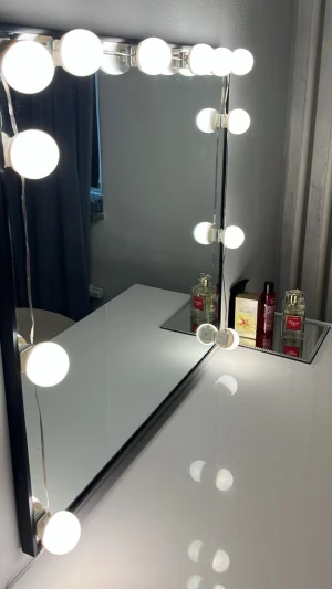 Sminkspegel med LED-lampor - Stilren sminkspegel med svart ram och stora runda LED-lampor runt hela spegeln. Perfekt för att få jämnt ljus när du sminkar dig. Spegeln har en modern, fyrkantig form och passar snyggt på sminkbordet.