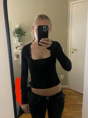 Svart långärmad topp från H&M Divided - Svart långärmad topp från H&M Divided med fyrkantig halsringning. Toppens passform är tight och den är croppad, perfekt för att matcha med jeans eller kjol. Materialet är mjukt och stretchigt, troligen bomull med lite syntet. Använt en gång 