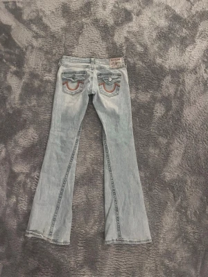True Religion ljusblå bootcut jeans - helt nya och knappt använda men det finns en liten fläck längst ner vid slutet men man märker knappt av den ! Innerbenslängden är cirka 77 cm och midjemåttet är cirka 30 rakt över! Men jag brukar ha xs i byxor och dom här passar mig perfekt! 