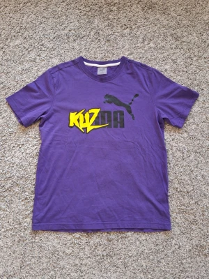Puma 'Kyle Kuzma' t-shirt - Snygg lila 'Kyla Kuzma' t-shirt från Puma i storlek M. Använd fåtal gånger och skicket ör riktigt bra. Stilig med alla olika outfits nu under sommaren. Skick: 9/10