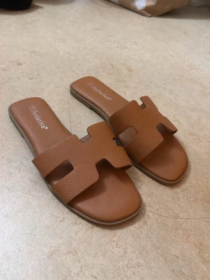 Bruna slip-in sandaler  - Säljer ett par bruna slip-in sandaler. Passar i 38-39
