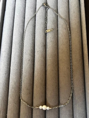 Silverfärgat halsband med pärlor - Den är inte från shein jag har gjort den själv! Stilrent halsband med tunn silverfärgad kedja och tre vita pärlor i mitten. Kedjan har ett justerbart lås och en liten bricka vid låset. Perfekt för dig som gillar minimalistiska smycken med en elegant touch.