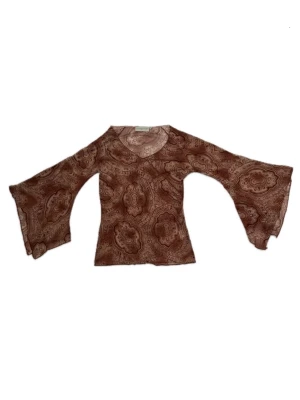 Ljusbrun mönstrad topp i mesh med vida ärmar - Unik brun topp i mesh med paisley-inspirerat mönster och v-ringning. Toppen har långa, vida ärmar som ger en bohemisk vibe. Orange/brun neutral färg. Storlek M men stretchigt material. 