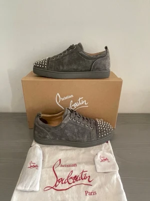 Christian Louboutin sneakers  - Christian Louboutin sneakers i storlek 43,5. Skorna är i fint skick och märkerna under sulan är något jag gått i bara. Ska gå att få bort. Låda, påse och snören fås med vid full pris eller om vi gjort ett tydligt avtal om det. 