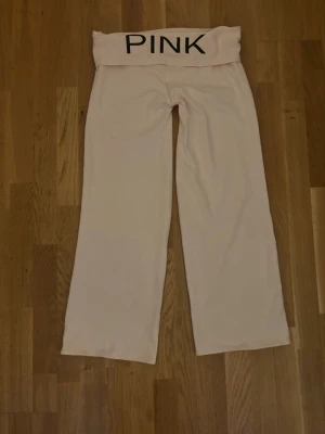 Ljusrosa mjukisbyxor från PINK - Supermjuka ljusrosa mjukisbyxor från PINK med bred mudd i midjan och utsvängda ben. Perfekta för chill eller när du vill vara extra bekväm. Materialet känns riktigt skönt mot huden och byxorna har en avslappnad passform. Om du intreserad jag vill bara förvarana att dom här byxorna är från en liten företag. som hetter jennifer.