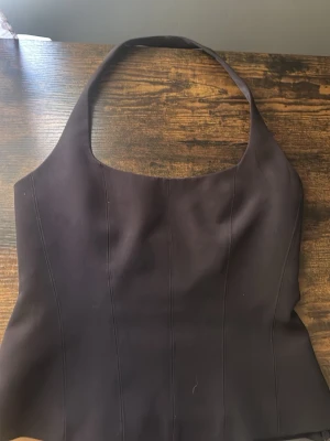 Svart halter neck topp från zara - Säljer en svart topp från Zara. Ser brun ut på bild pågrund av ljuset men är svart Igentligen. Andvänt 2 gånger 