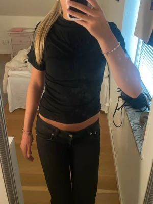 Svart tight kortärmad t-shirt - En enkel och stilren svart t-shirt med tight passform och korta ärmar. Perfekt basplagg till alla outfits. Tillverkad i mjukt material som sitter skönt mot kroppen.
