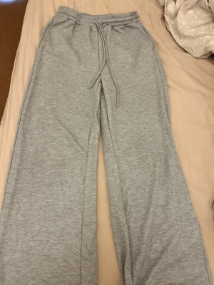 Grå mjukisbyxor från SHEIN - Säljer ett par ljusgrå mjukisbyxor från SHEIN i storlek M. Byxorna har resår i midjan med dragsko och raka ben. Tillverkade i mjukt och bekvämt material, perfekta för chill dagar hemma eller när du vill vara extra comfy.
