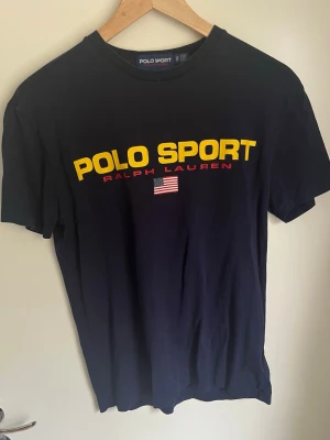 Ralph Lauren T-shirt - Säljer en T-shirt från Polo Sport Ralph Lauren. Marinblå. Mycket bra skick utan defekter. Storlek XS.