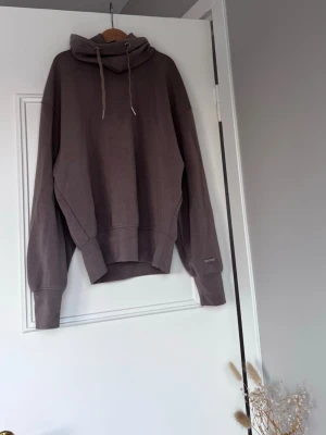 Polo hoodie från Stronger  - Säljer en polo överdrags tröja med dragsnören. Den har breda muddar vid ärmslut och midja samt en liten metallbricka med logga på ärmen. Tillverkad i mjukt material som är funktionellt för träning 