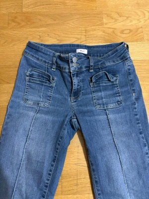 Low waist blå bootcut jeans  - Säljer ett par blåa low waist jeans, de är i storlek 38