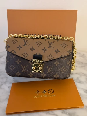 Iouis vuitton pochette métid - Tidlös elegans ✨ Iouis Vuitton Pochette Métis East-West i det ikoniska Monogram Reverse-mönstret. En perfekt balans mellan klassiskt och modernt. Den ultimata väskan för både vardag och fest! 👜