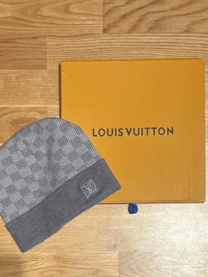 LV MÖSSA - Säljer en fin grå Louis Vuitton mössa för billigt pris! Mössan har bra kvalitet!