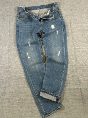 Levi’s 511 Rugged Americana  W30 L32 - Mid Rise Denim - Levi’s 511 slim fit jeans with a clean mid-rise and tapered leg. Perfect worn-in fade with natural whiskering + light distressing for that effortless vintage look. Easy everyday denim - sneakers or boots, works with everything.  Waist 49cm, Length 101.5cm, Rise 24cm, Thigh 27cm, Knee 20cm, Foot 17.2cm.  Used condition with small rips/marks - adds character.