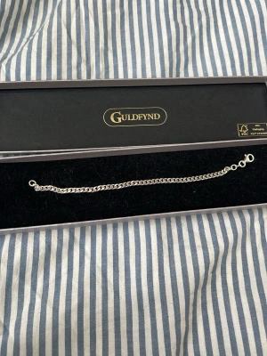 Silverarmband från Guldfynd - Säljer ett stilrent silverarmband från Guldfynd med klassisk kedjedesign. Armbandet har en enkel och elegant form med flera små länkar och justerbar längd. Perfekt för dig som gillar minimalistiska accessoarer.