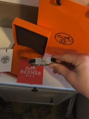 H svart och silver armband - Snyggt armband från H i svart och silver med den ikoniska H-detaljen framtill. Armbandet har en stilren och modern design som verkligen sticker ut. Kommer med originalask och påse från H.