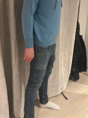 Blå Hoodie - Säljer ett par ljusblå jeans i slim fit-modell. Jeansen har klassisk femficksdesign, normal midja och är tillverkade i denim med snygg tvätt. Passar dig som gillar en smalare siluett och stilren look. Den är helt ny använd max 2 gånger och inga defekter, riktigt bra material och asskön att ha på sig, jag är 173
