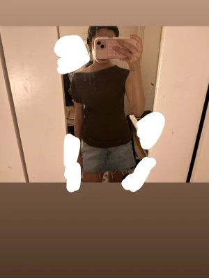 Brun offshoulder topp - Snygg brun topp med offshoulder-design och korta ärmar. Toppen har en enkel, stilren look och är lätt att matcha med olika outfits. Perfekt för dig som gillar en trendig och avslappnad stil.