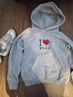 Ralph Lauren hoodie - Grå hoodie med trycket 'I ♥ Polo' på bröstet. Klassisk känguruficka framtill och huva med dragsko. Skriv för fler bilder eller frågor.