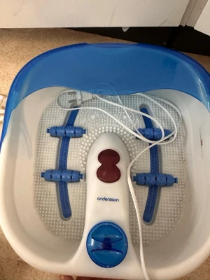 Fotspa med massage från Andersson - Elektriskt fotspa från Andersson i vit och blå plast med massagefunktion och bubblor. Utrustad med fyra blå massagehjul, kontrollpanel och elsladd. Perfekt för avkoppling hemma och enkel att använda med vatten.