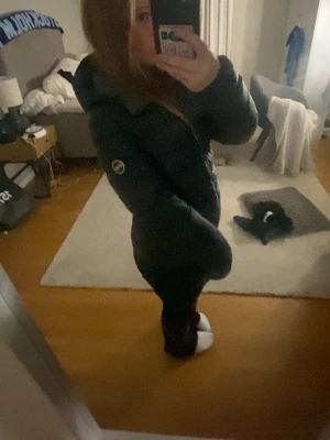 Colmar jacka (Svart dunjacka) - Säljer en svart dunjacka med huva från colmar  med dragkedja. Jackan har en figurnära passform och en patch på ärmen. Perfekt för kalla vinterdagar och riktigt skön att bära. Snygg och enkel att matcha med olika outfits.