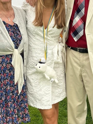 Vit omlottklänning från Vila - Supersnygg vit omlottklänning från Vila med blommigt strukturmönster och puffärmar. Klänningen har knyt i midjan och v-ringning. Perfekt till student eller sommarens alla tillfällen! Endast använd en gång och kommer tyvärr inte till användning längre!