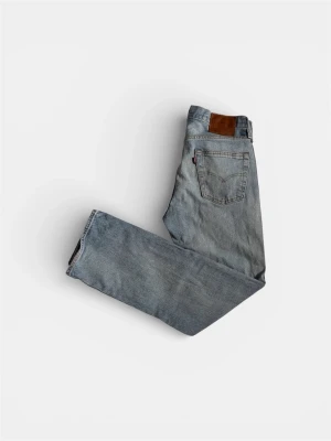 Ljusblå Levi's raka jeans - Säljer ett par klassiska ljusblå jeans från Levi's med rak passform och femficksmodell. Jeansen har en brun läderpatch bak i midjan och den ikoniska röda Levi's-taggen på bakfickan. Tillverkade i slitstark denim, perfekta för en avslappnad look.                        W30 L32