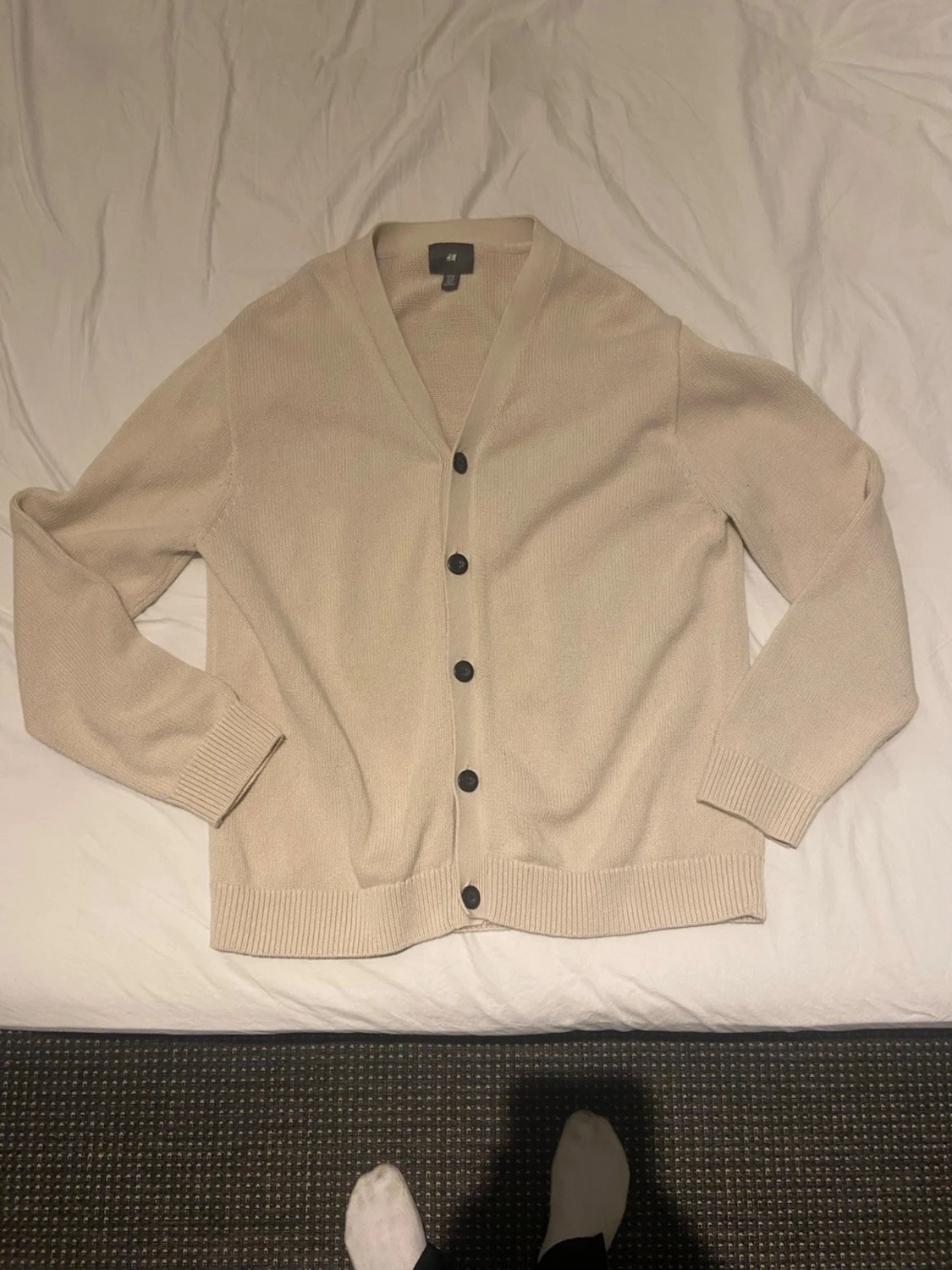 Beige kofta med svarta knappar