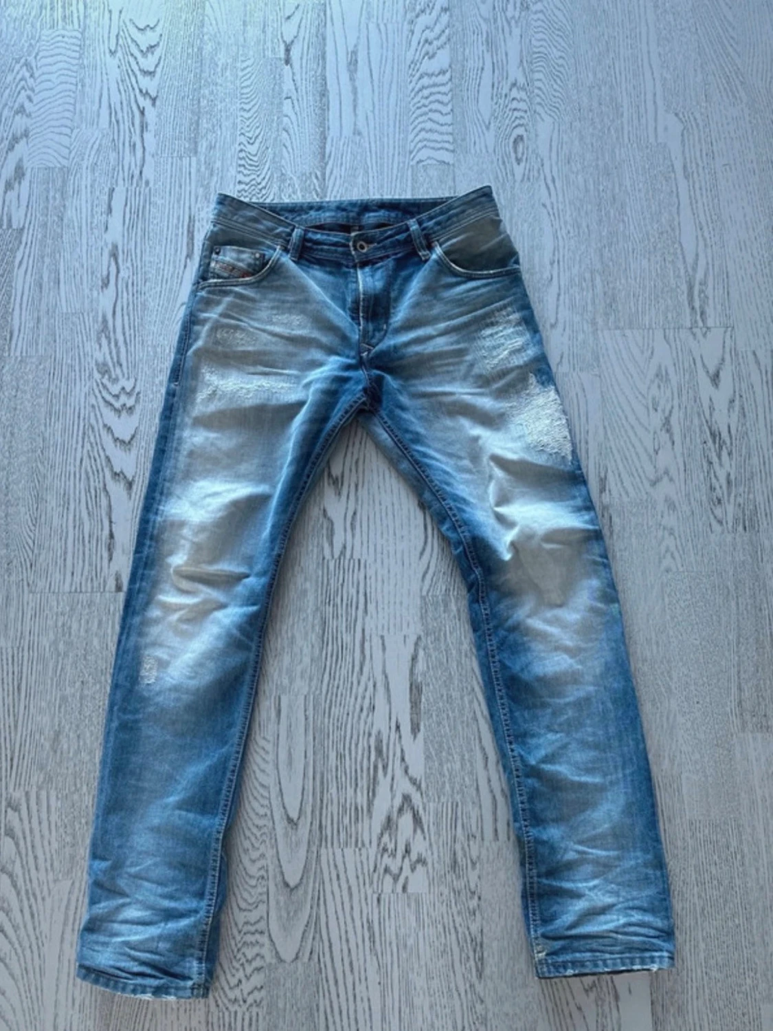 Blå slitna jeans med patchdetaljer
