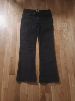 Svarta bootcut jeans från 152 - Säljer ett par svarta bootcut jeans från 152. Jeansen har utsvängda ben, klassisk femficksdesign och knappgylf. Snygga att matcha med sneakers eller boots för en avslappnad look.