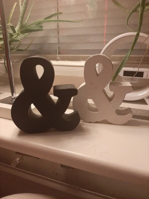 Dekorativa &-tecken i trä - Två dekorativa &-tecken i trä, ett svart och ett vitt. Perfekta som inredningsdetaljer på hyllan, skrivbordet eller i fönstret. Snygg och stilren design som passar i de flesta rum. Säljes tillsammans.