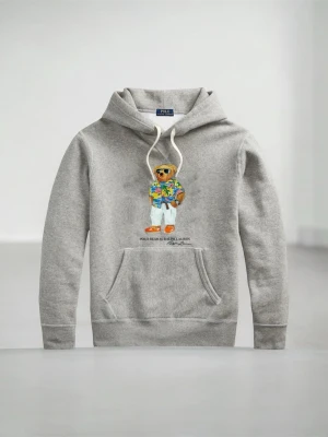  Polo Ralph Lauren Hoodie  - Snygg grå hoodie från Polo Ralph Lauren med klassisk björn-motiv på bröstet. Hoodien har huva med vita snören, stor magficka och ribbade muddar. Perfekt för dig som gillar streetstyle och ikoniska prints.