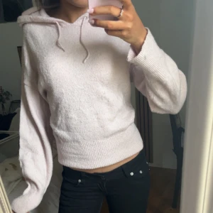 Ljusrosa hoodie från Gina Tricot - Mysig ljusrosa hoodie från Gina Tricot med huva och dragsko. Tillverkad i mjukt stickat material och har breda ribbade muddar vid ärmslut och nederkant. Perfekt för en avslappnad och trendig look.