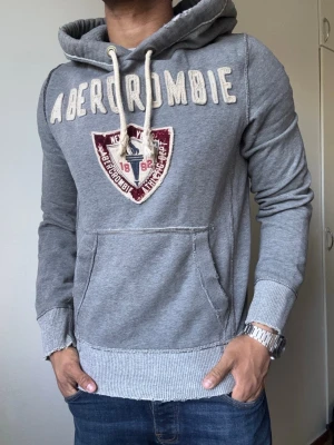 Vintage Abercrombie & Fitch Hoodie - Säljer denna as snygga Abercrombie & Fitch Hoodien | Mycket bra skick, litet hål/skav på baksidan (sista bild)  | Storlek S | Längd ≈ 67cm, Bredd armhåla-armhåla ≈ 57cm | Modell 175cm, 68kg | Hör av vid funderingar! 