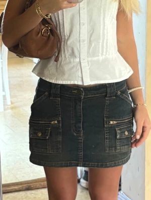 Mörkblå jeanskjol med fickor - Cool och unik mörkblå jeanskjol med flera framfickor, dragkedjor och knappdetaljer. Köpte nu i Australien för 50 aud (335kr). Storlek xs skulle jag säga, jättefint skick helt utan defekter!