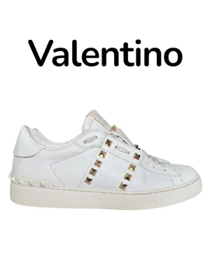 Valentino rockstuds 38,5 - Snygga vita sneakers från Valentino i läder med ikoniska guldfärgade nitar längs sidorna och runt hälen. Klassisk låg modell med vita skosnören och diskret logga på plösen. Perfekta för dig som vill ha en clean look med edgy detaljer. Storlek 38,5 och i väldigt fint skick