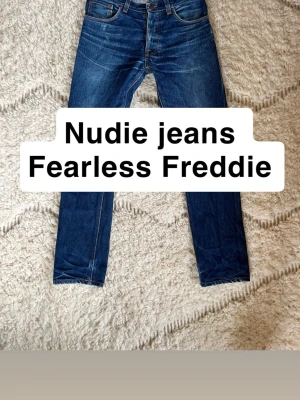 Nudie Jeans Fearless Freddie blå jeans - Säljer ett par sjukt snygga Nudie Jeans Fearless Freddie. Riktig snygga nartuliga fades. De har blivit professionellt lagade vid skrevet men inga andra konstigheter Storlek 31/32. Bara säg till om det är något du undrar!