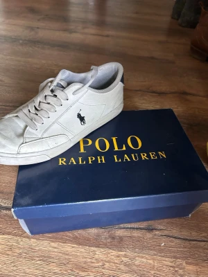 Polo Ralph lauren skor - Stilrena vita sneakers från Polo Ralph Lauren med klassisk logga på sidan. Skorna är perfekta för sommarn i en stilren vit färg. Skorna är använda  och säljer lite billigare på grund av små skavanker.Pris kan diskuteras 