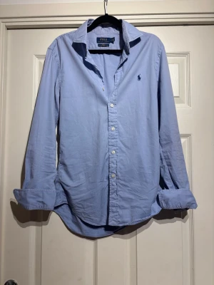 Blå Ralph lauren skjorta  - Säljer denna snygga blå skjorta från Polo Ralph lauren. Perfekt nu till sommaren!